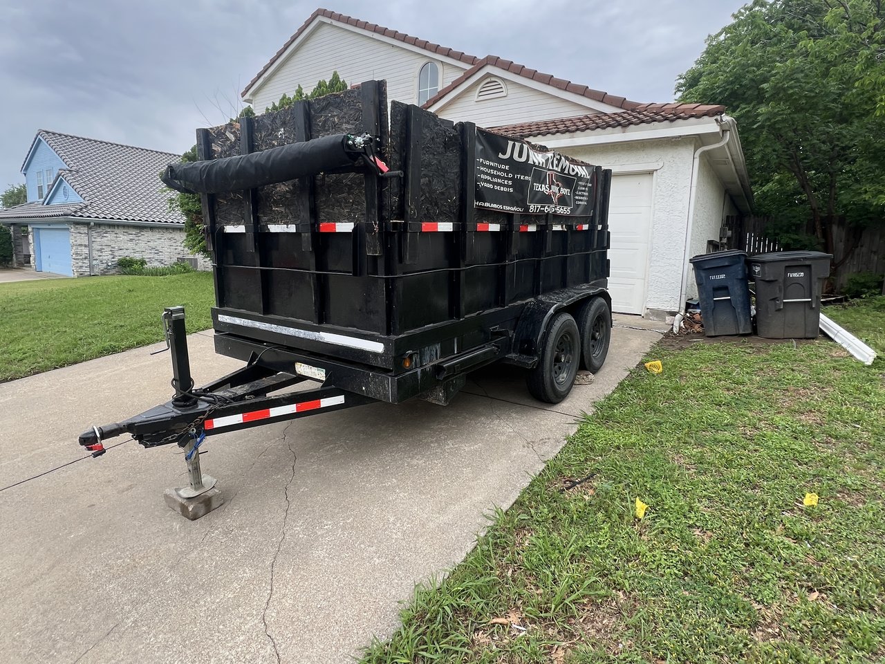 Texas Junk Boyz branded rental dumpster delivered to a residential driveway